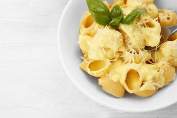 Portion of delicious pasta with cheese on wooden background