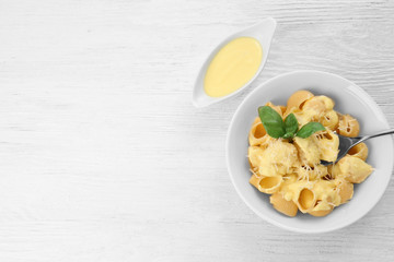 Portion of delicious pasta with cheese on wooden background
