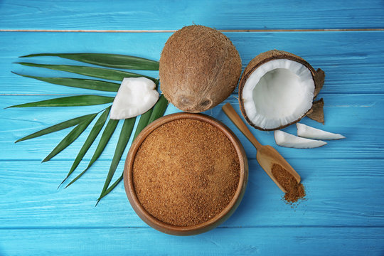 Bowl of brown sugar and coconut on wooden background