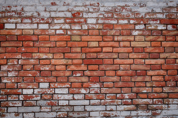 Brick wall with shabby whitewash peeled in