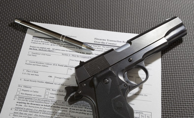 Semi-auto pistol on top of the 4473 firearm transfer paperwork to get an FBI background check to...