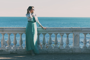Amazing young woman in green dress near the sea