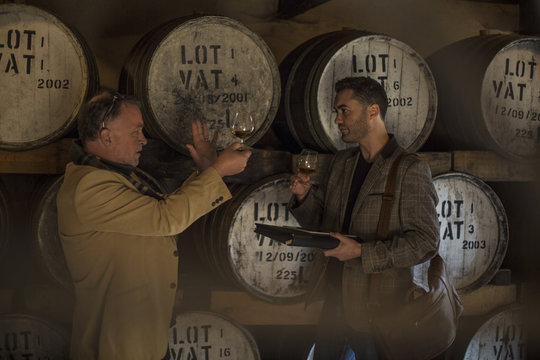 People in distillery tasting whiskey