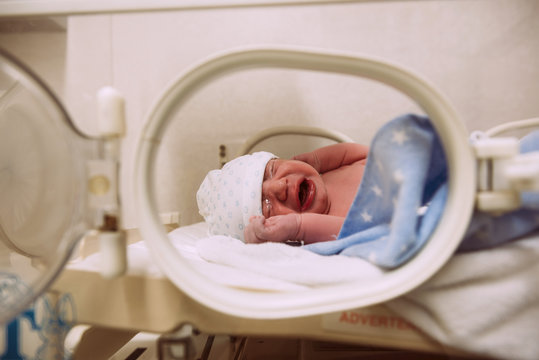 Crying newborn baby in an incubator