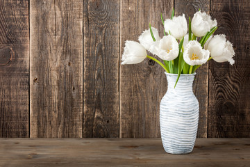 Fresh white tulips bouquet in jug
