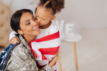 Thankful mother receiving a kiss from her child