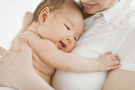 Close-up of mother holding her baby boy in her arms