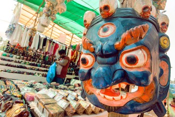 Indian souvenir market with old wooden mask of Mahakala deity, popular in Hinduism and Buddhism