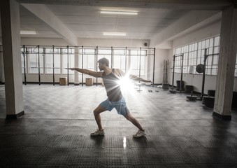 Fototapeta na wymiar Man stretching in gym with flare