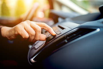 Turning on radio at car driving home.