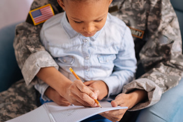 Caring sweet mom teaching her daughter to write