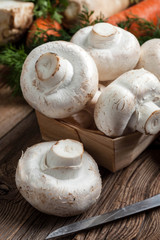 Champignon mushrooms on a wooden cutting board.