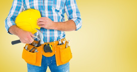 Carpenter with hammer against yellow background