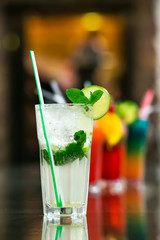 Two fresh mojitos cocktail on wooden background. Mojitos with mint leaves, lime and ice.
