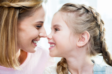 Close-up portrait of happy mother and daughter looking at each other