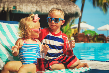 Fototapeta na wymiar kids relax on tropical beach resort and drink juices