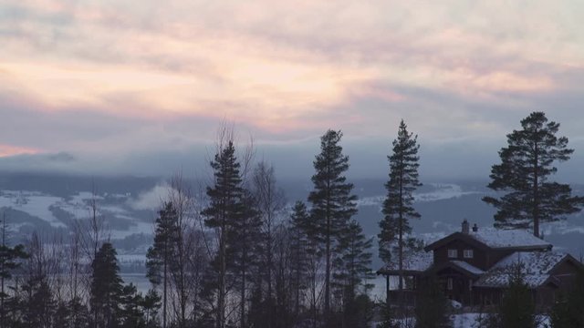 Winter sunset over Strandlykkja lodge with Mj&oslash;sa lake on background,  Hedmark, Norway