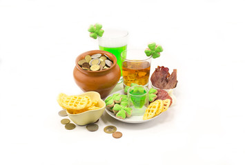 Fototapeta na wymiar Beer a green glass with whiskey and a pot of coins with not many snacks and a pile of skulls. Party of leprechauns on St. patrick's day