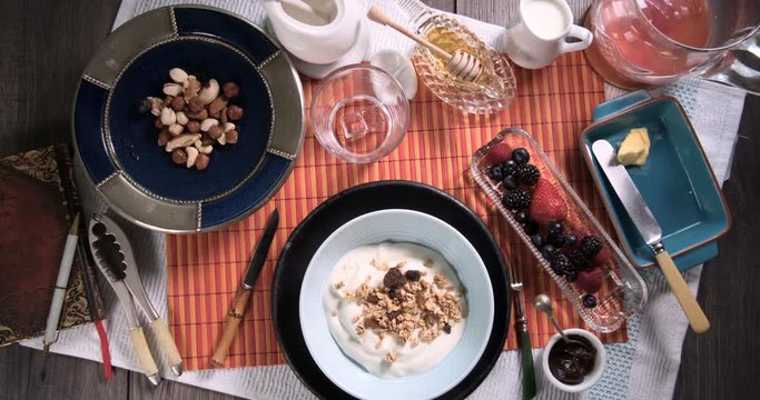 Stop motion view of a healthy breakfast of yogurt, cereals, berries and dry fruits