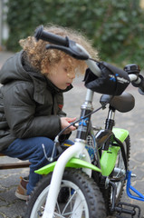 Fototapeta na wymiar Kleinkind repariert baut bastelt an seinem Fahrrad