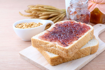 Bread with jam grape on wood background