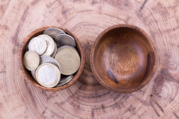 Coins in wooden bowl