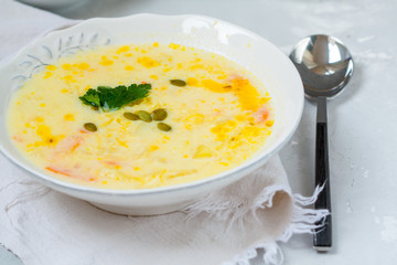 Cheese and vegetable soup puree in a white plate with parsley and croutons.