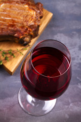 Glass of red wine and rib eye beef steak. Wine and meat still life. View from above, top studio shot