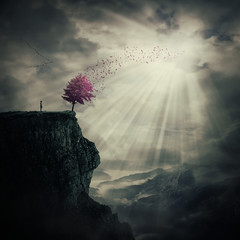 Young man standing on the peak of a cliff watching at a strange, purple tree that cast its leaves...