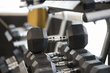 Closeup of weightlifting dumbbells on a rack in a gym 