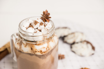 Hot chocolate with marshmallow on the wooden background. Shallow depth of field.