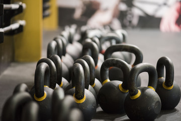 Large grouping of kettlebells in a cross fit gym with a blurred background 