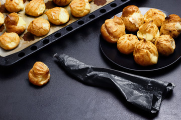 Profiteroles eclairs .Eclair on baker tray defocused.Copy space Selective focus