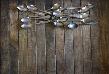 Silver plate vintage utensils on old wood background