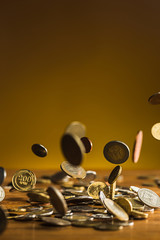 The silver and golden coins and falling coins on wooden background