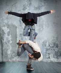 Fototapeta na wymiar Two man break dancing on wall background