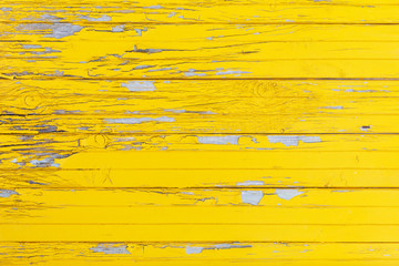 Horizontal background of the old wooden planks with cracked yellow paint