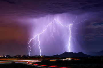 Naklejka na ściany i meble Lightning bolt strike from a storm over a city