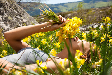 femme couchée dans l'herbe avec un bouquet de coucous © plprod