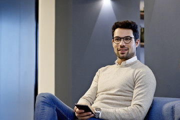 Caucasian businessman with mobile device having a discussion in an office
