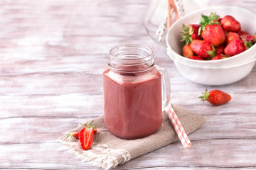 Strawberry smoothie or milkshake in jar on white wooden rustic background