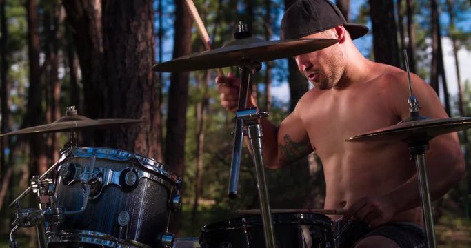 Musician Beating the Drums in the Forest