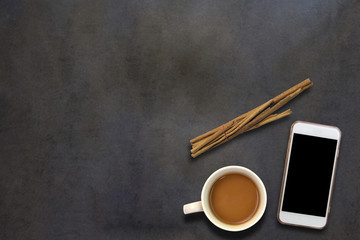 Cellphone and coffee on dark wooden background,top view