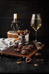 Fototapeta na wymiar Grilled chestnuts on a wooden board and a glass of wine