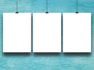 Three blank frames against aqua painted concrete wall background