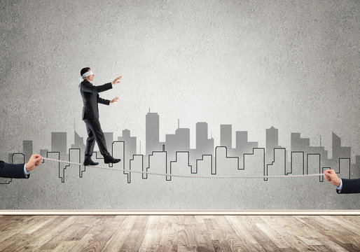 Business concept of risk support and assistance with man balancing on rope