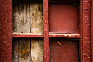 Part of door with four small windows, what clogged with plaque. The old red paint on the door