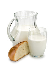 Piece of a white loaf and glassware filled with milk