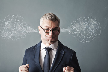 Closeup portrait of angry businessman, blowing steam coming out of ears