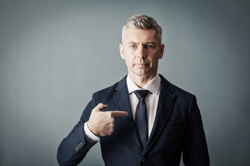 Businessman is pointing at himself